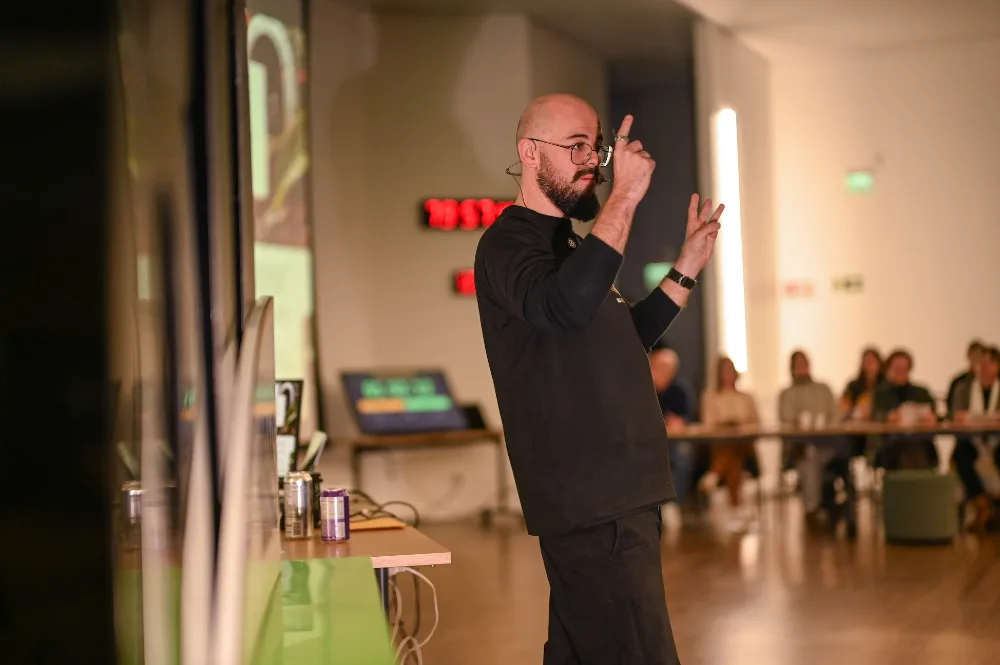 Matheus Boesing teaching in the auditorium, with the timers in the background